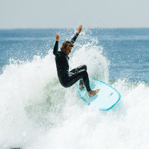 surfer performing an off-the-lip turn on a blue surfboard